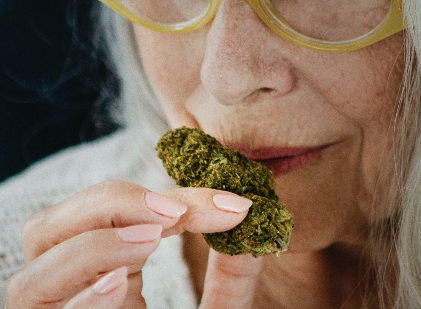 FEMME AGÉE QUI SENT UNE FLEUR DE CBD NEOWEED